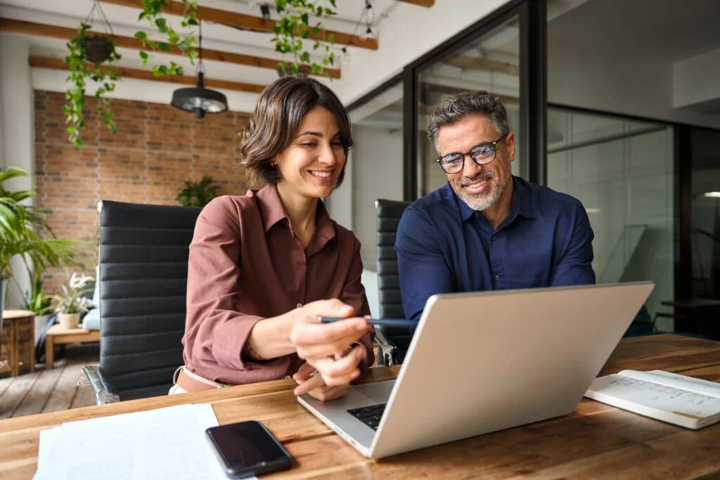 a man and woman looking at a laptop